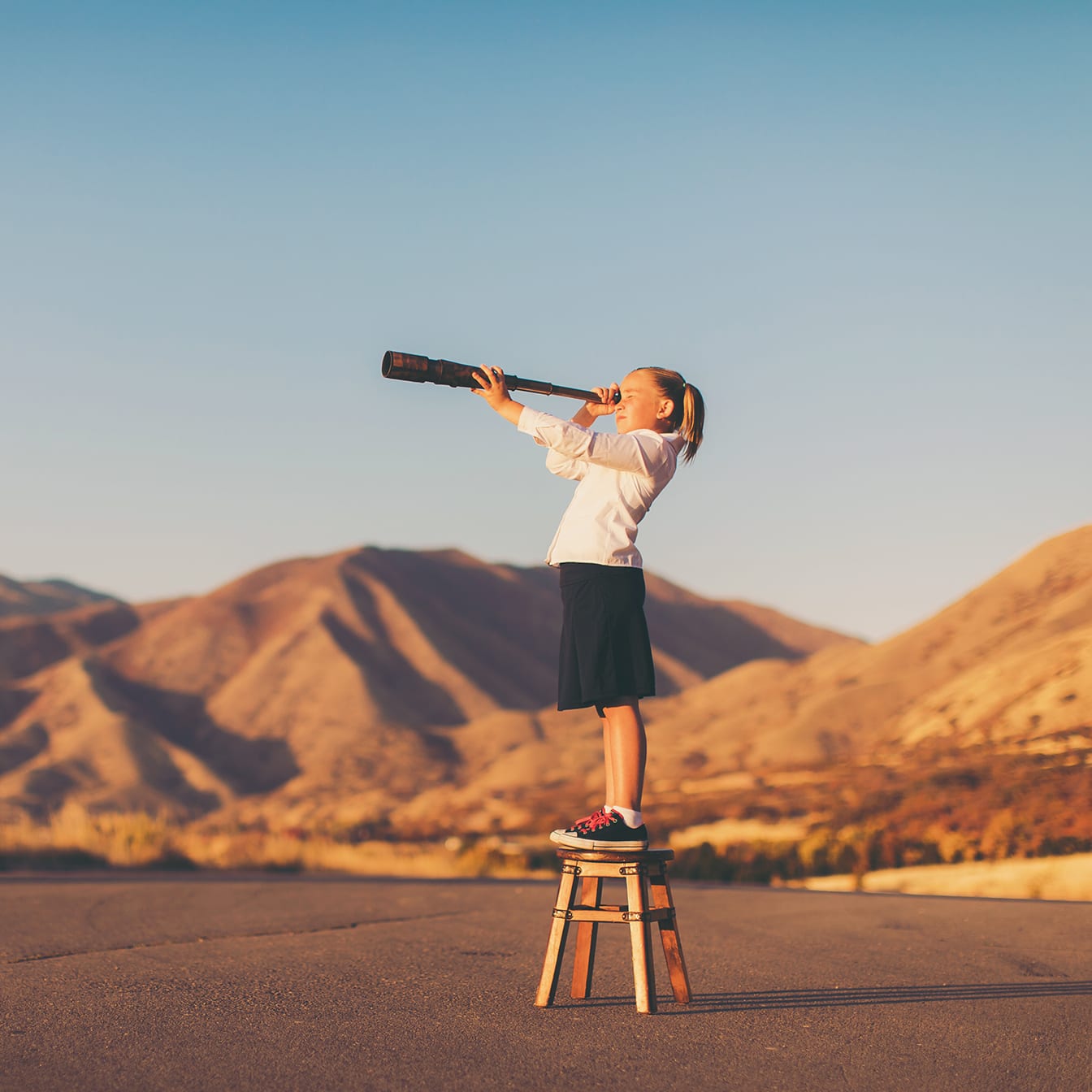 Young Business Girl Looks through Telescope